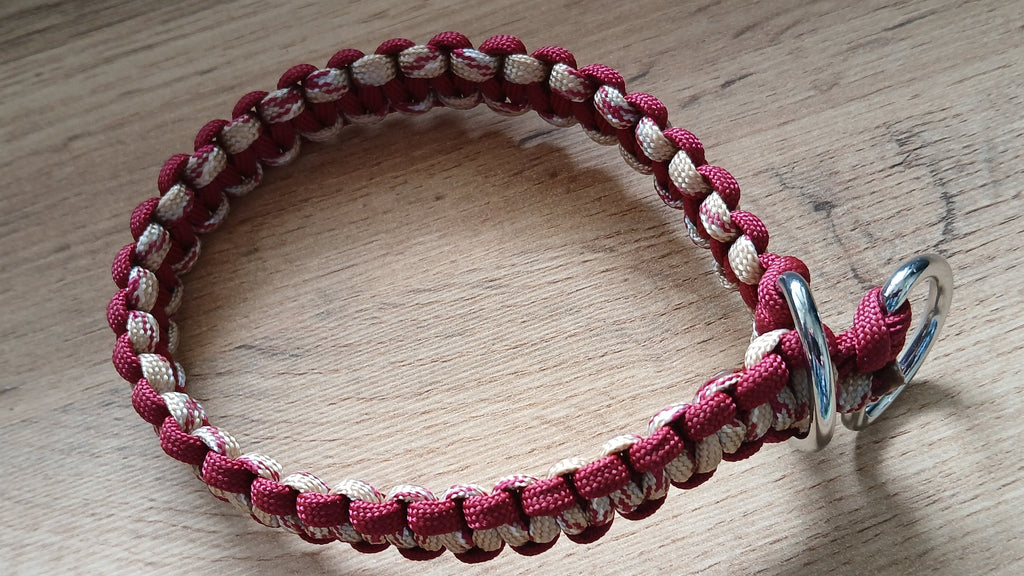 Paracord dog collar with metal ring on a wooden surface