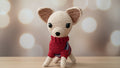 Crocheted Chihuahua desk buddy wearing a red sweater on a wooden surface with a blurred light background 
