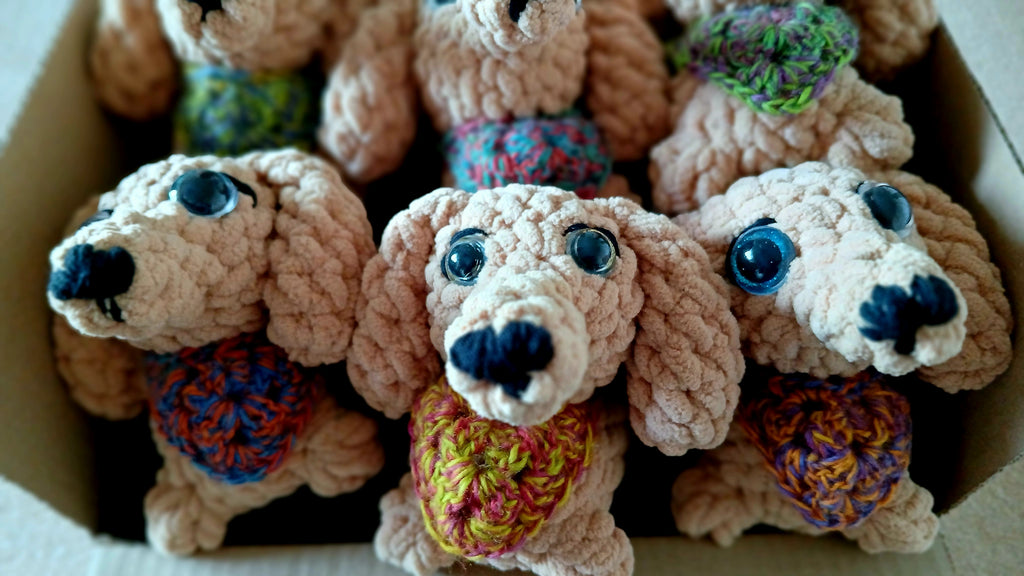 Crocheted dog toys with colorful scarves in a box