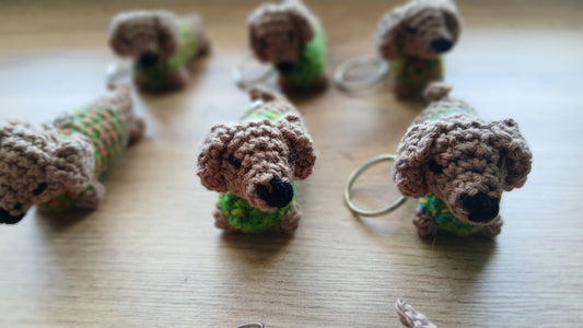 Front of dachshund keychains wearing green sweaters