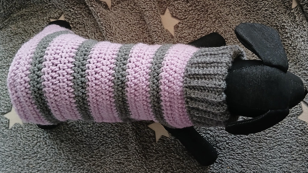 A dog mannequin wearing a striped grey - lilac pullover, view from above