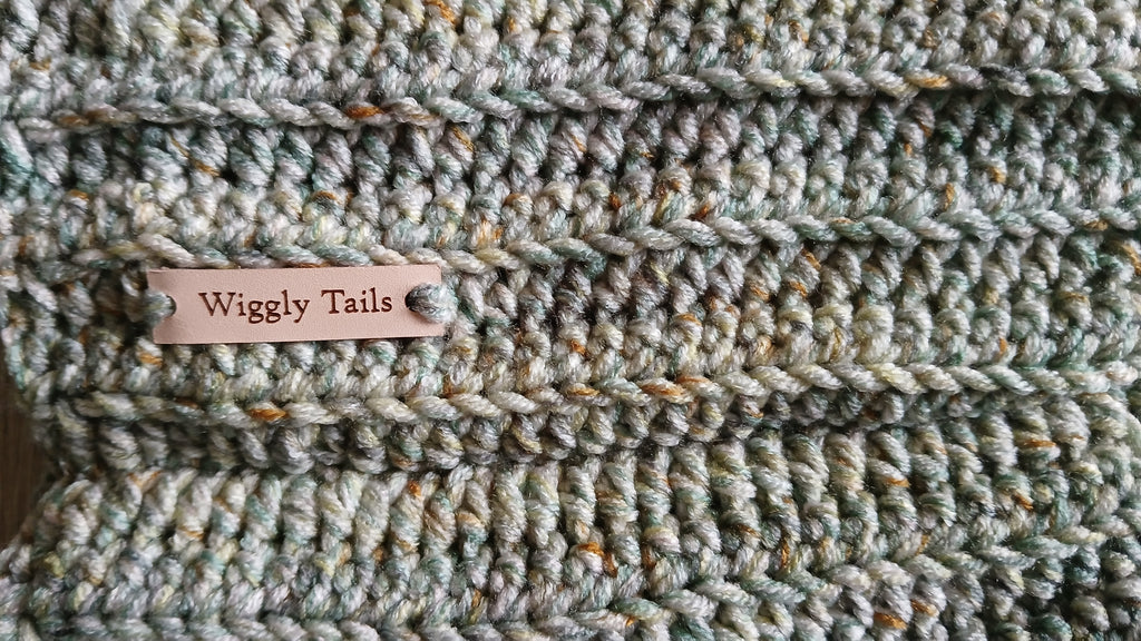 Close up of a light green crochet dog snood