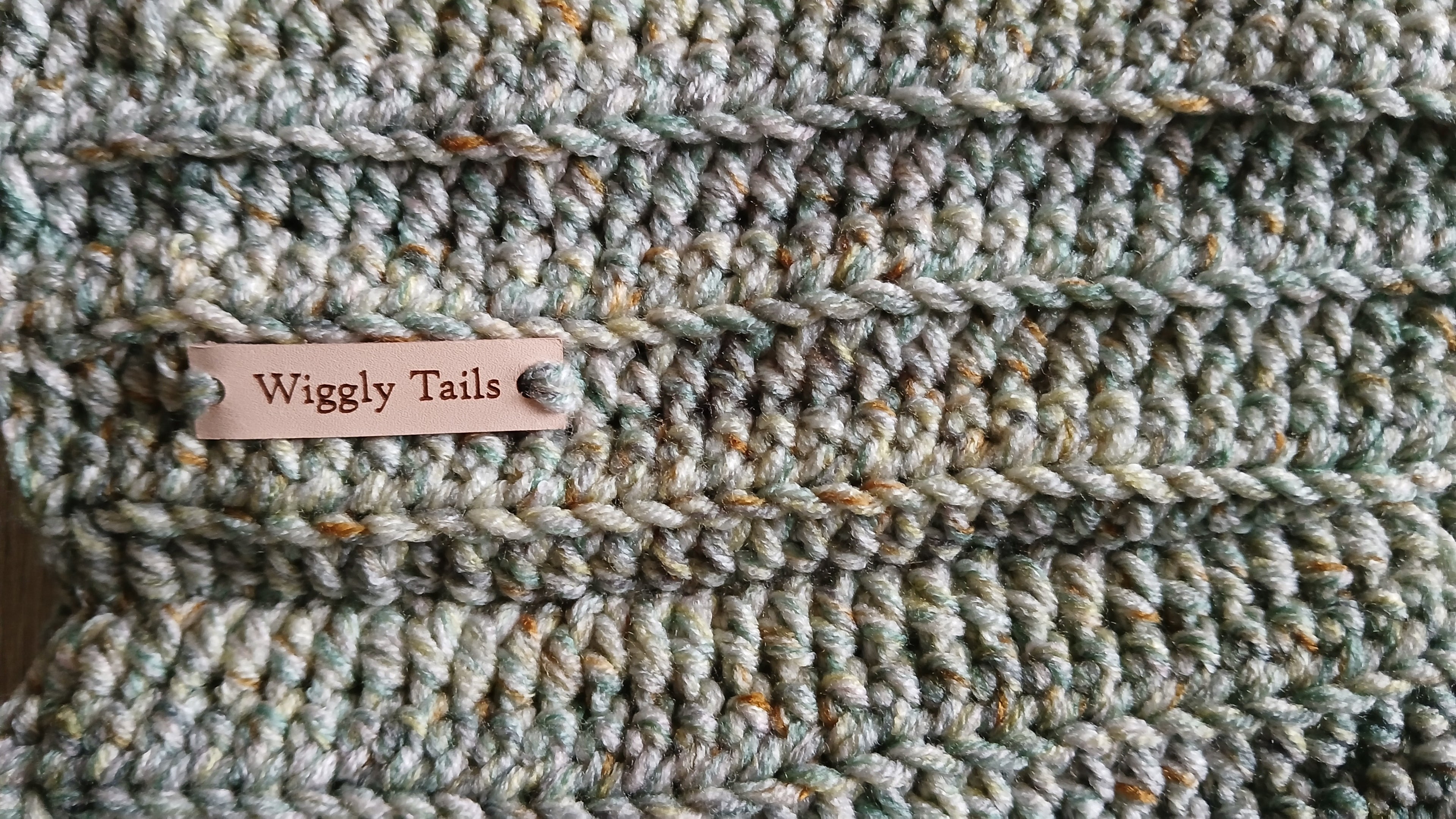 Close up of a light green crochet dog snood