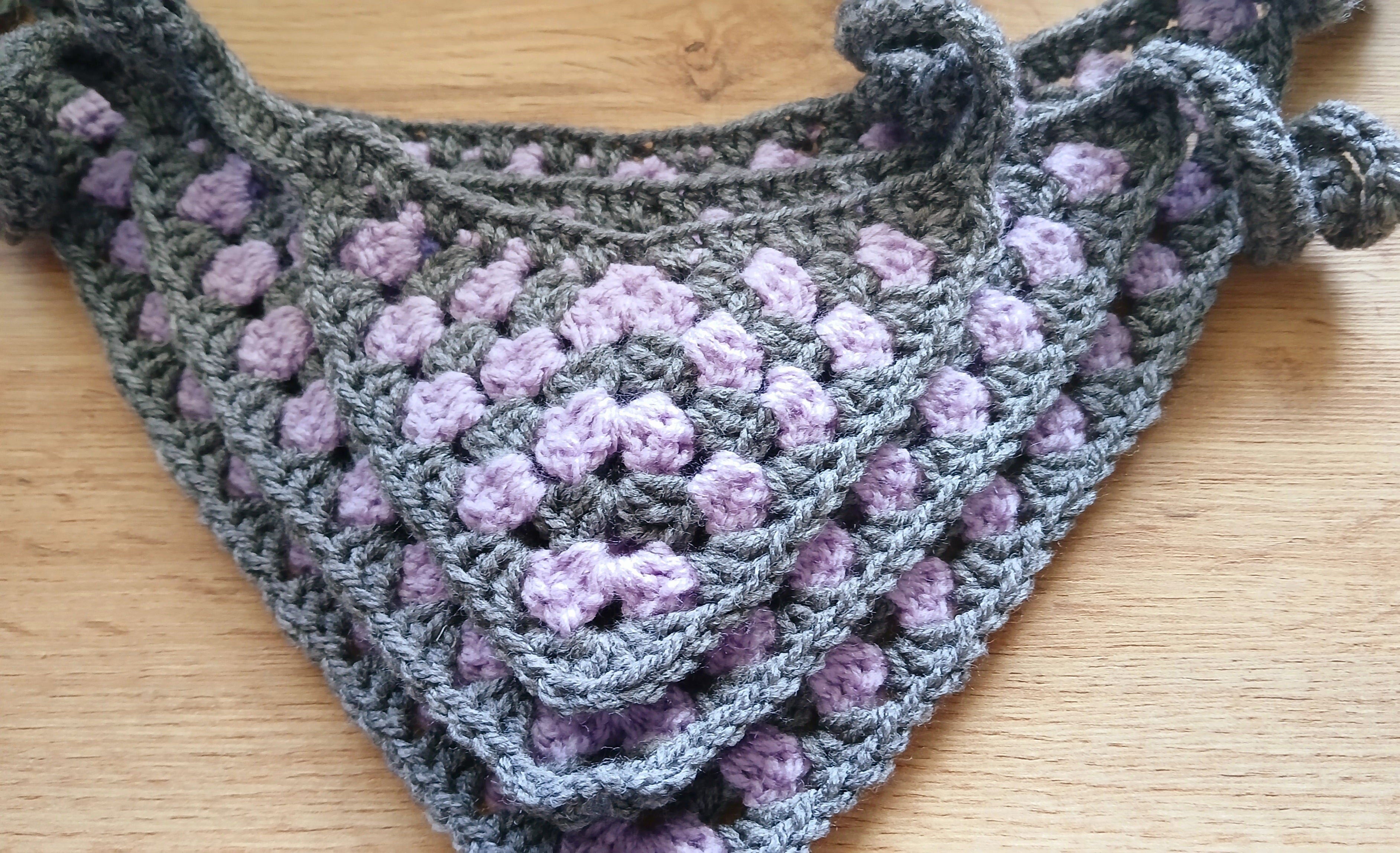 A stack of crochet dog bandanas in light purple and grey