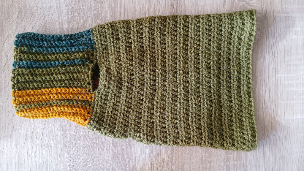 A flatlay of olive green dog sweater with unfolded turtleneck 