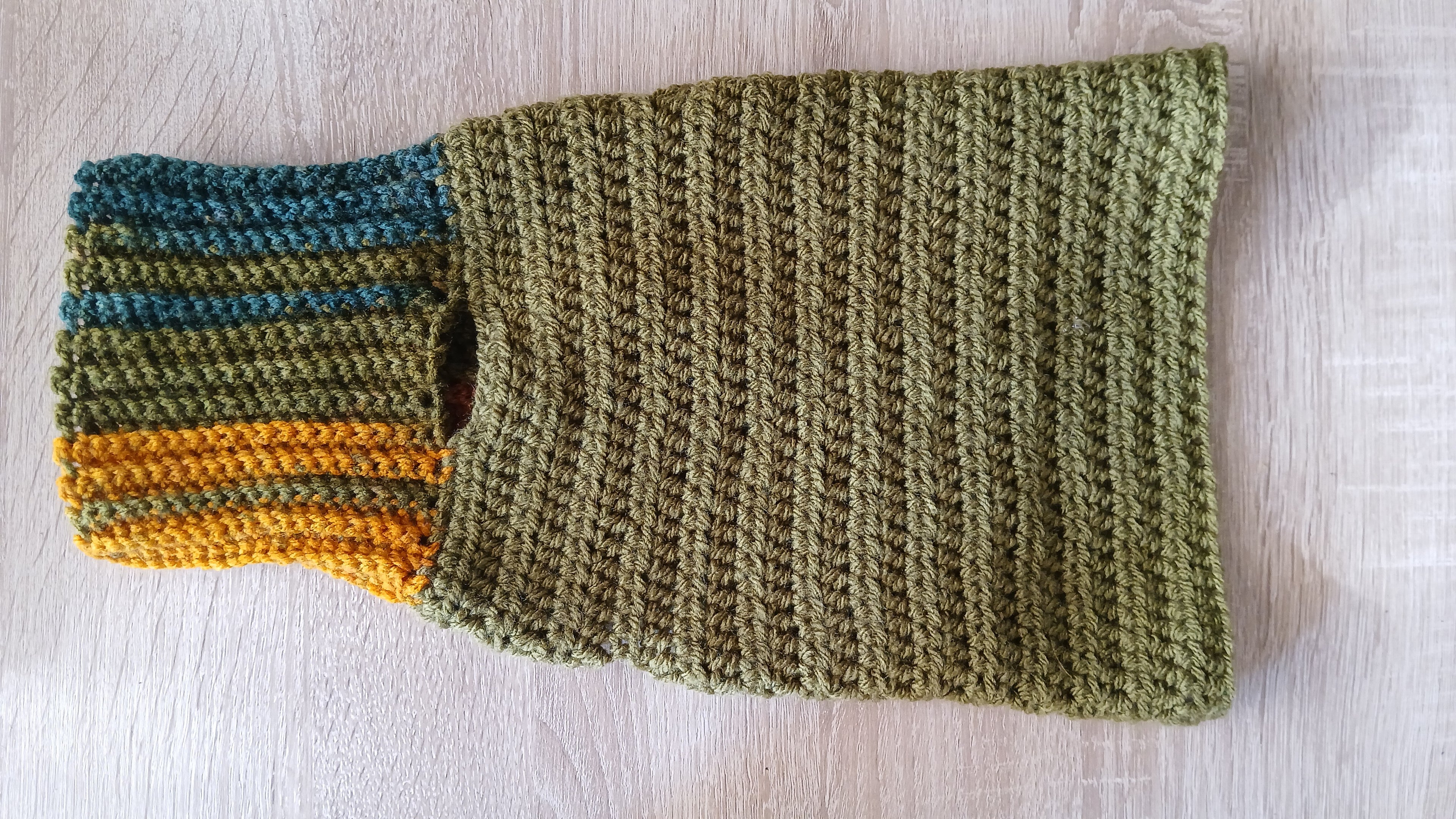 A flatlay of olive green dog sweater with unfolded turtleneck 