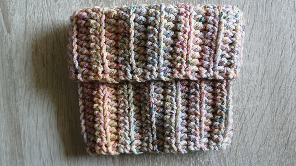 A dog snood laying flat on the table, folded like a turtle neck