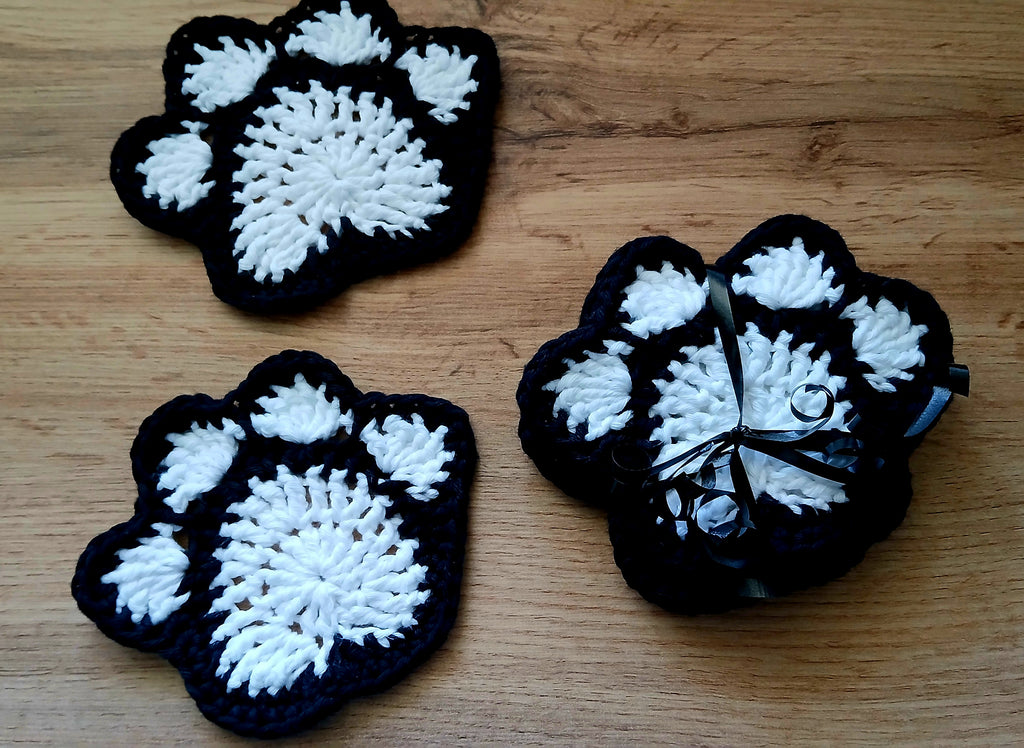 Set of black and white coasters shaped like paw prints