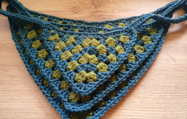 A stack of dog bandanas in multiple sizes, turquoise and green 