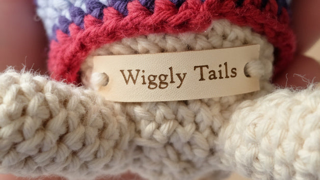 Close-up of a crochet product with a 'Wiggly Tails' label.