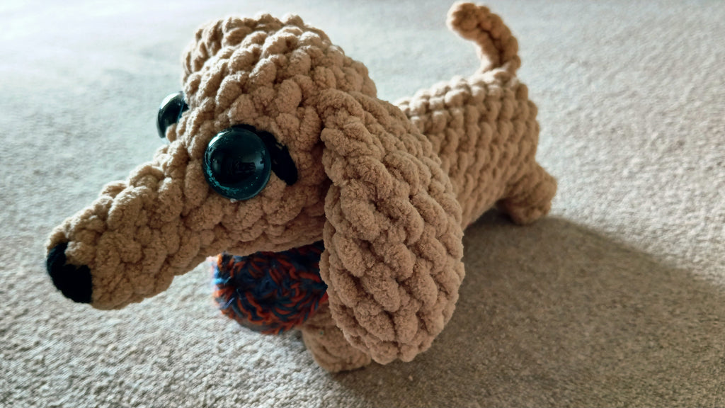 dachsund plushie with a crochet bandana in blue and orange